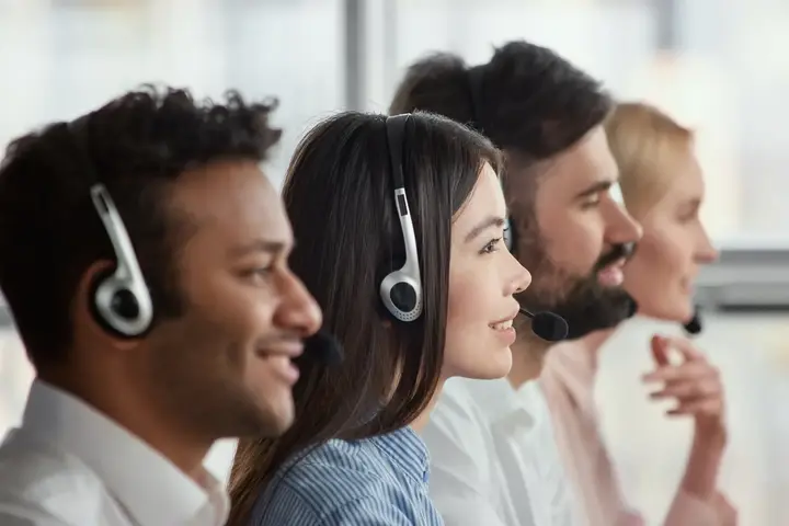 Asesora atendiendo clientes junto a un equipo de contact center