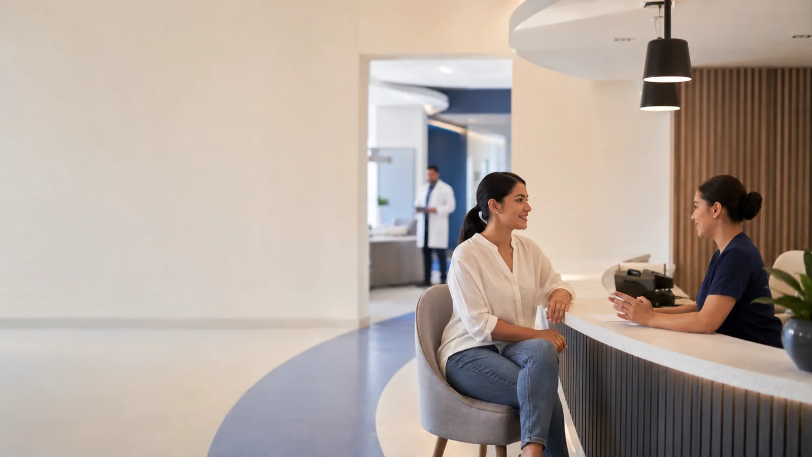 Paciente y coordinadora conversando en la recepción de una clínica latinoamericana moderna